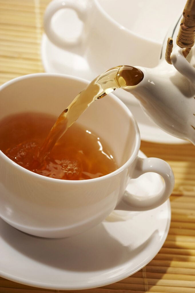 tea being poured in a white tea cup tea party ideas