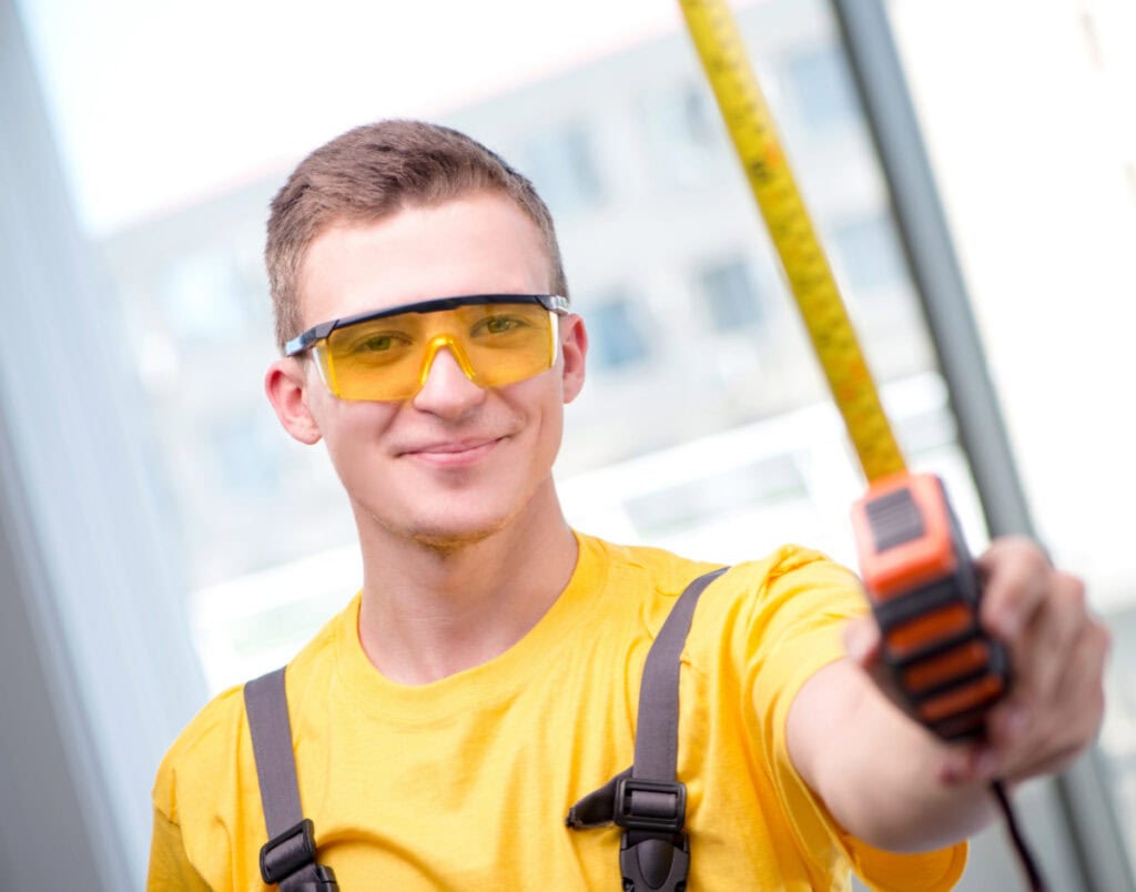 teenage boy learning to use a measuring tape