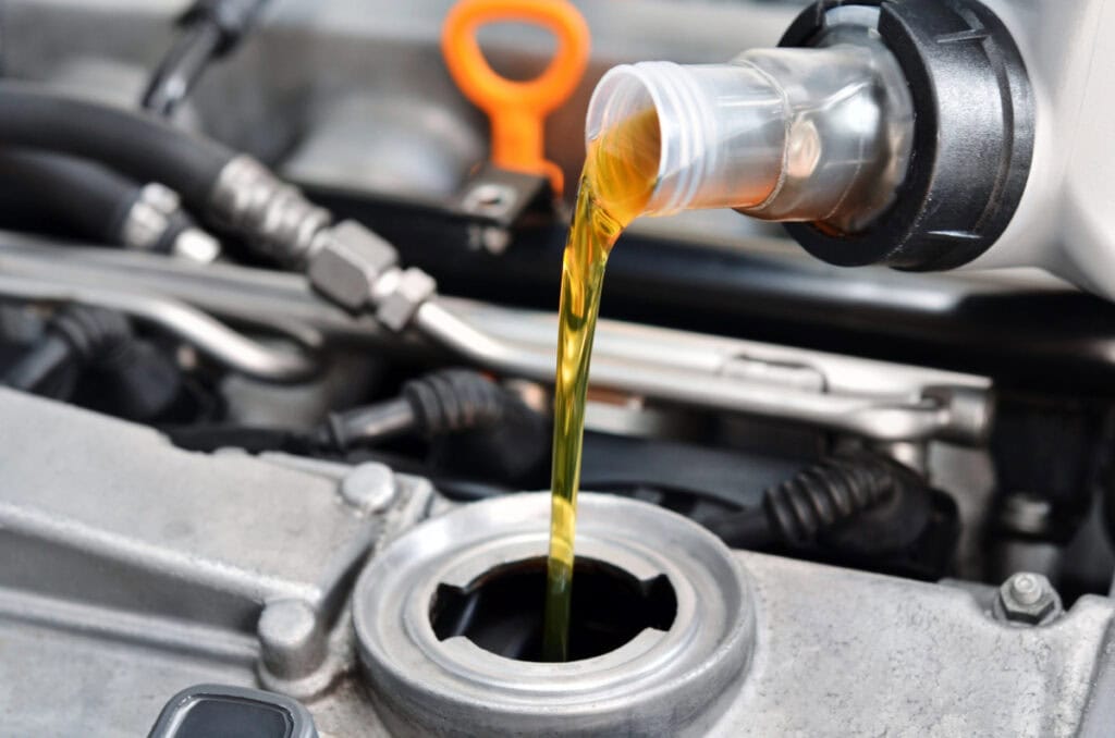 vehicle engine with oil being poured in