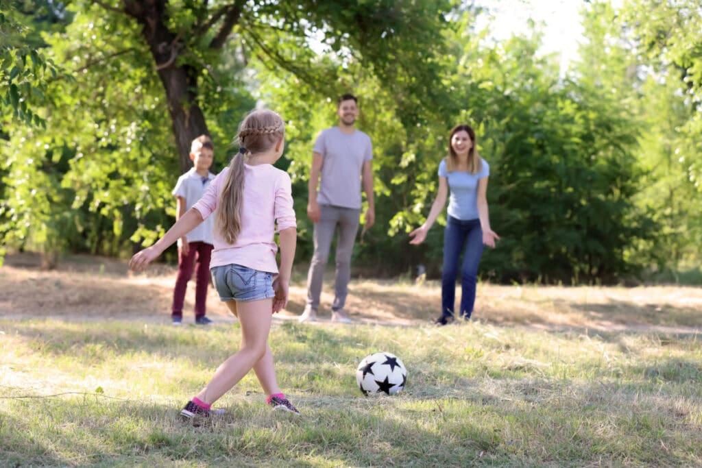 family playing soccer outdoors