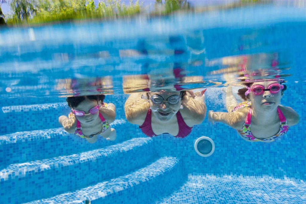mom and daughters swimming under the water