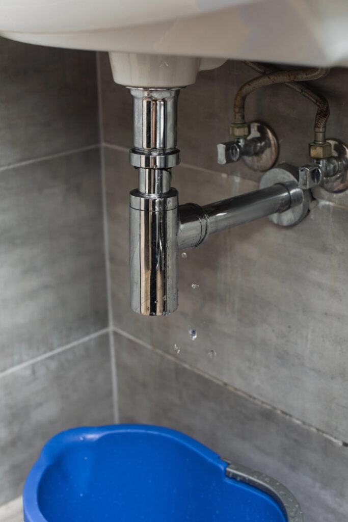 leaking bathroom sink with bucket underneath
