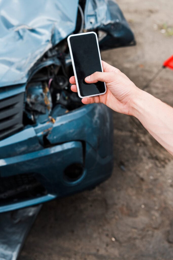 person taking a picture of a car that was in an accident