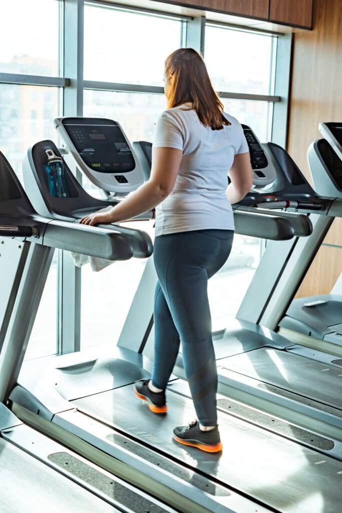 woman walking on a treadmill on a weight loss journey