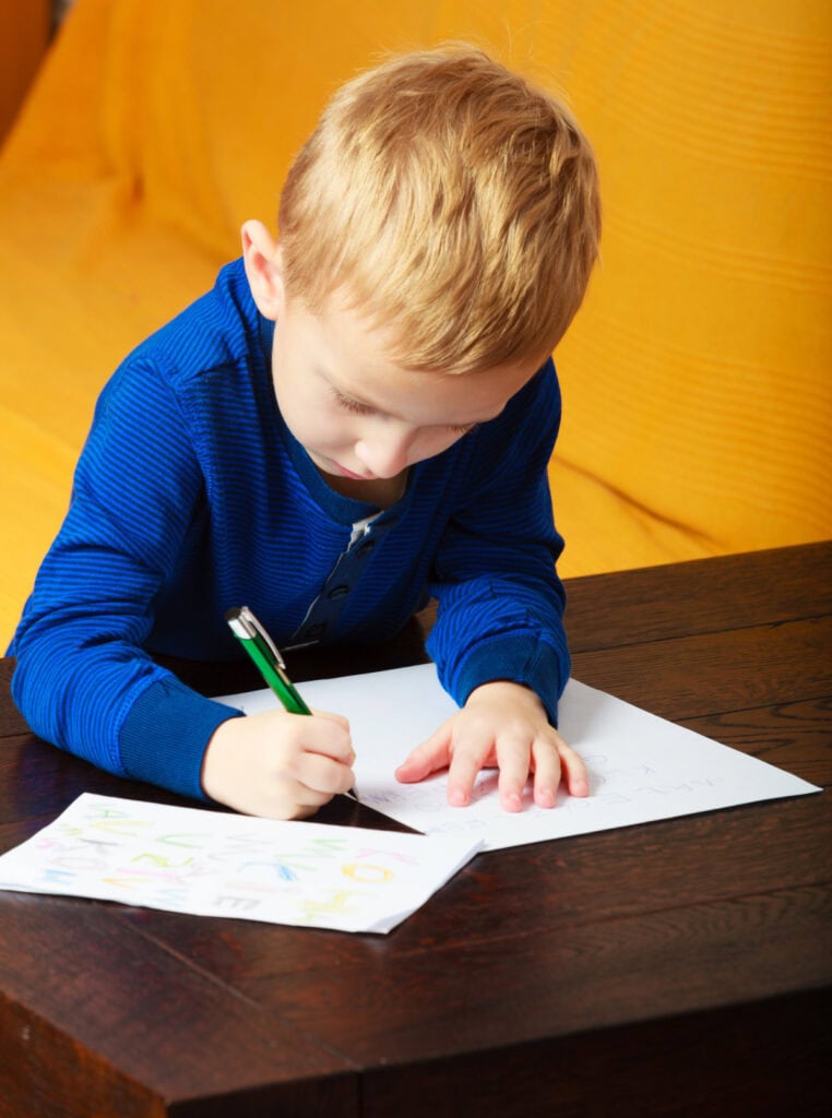 little boy writing on paper