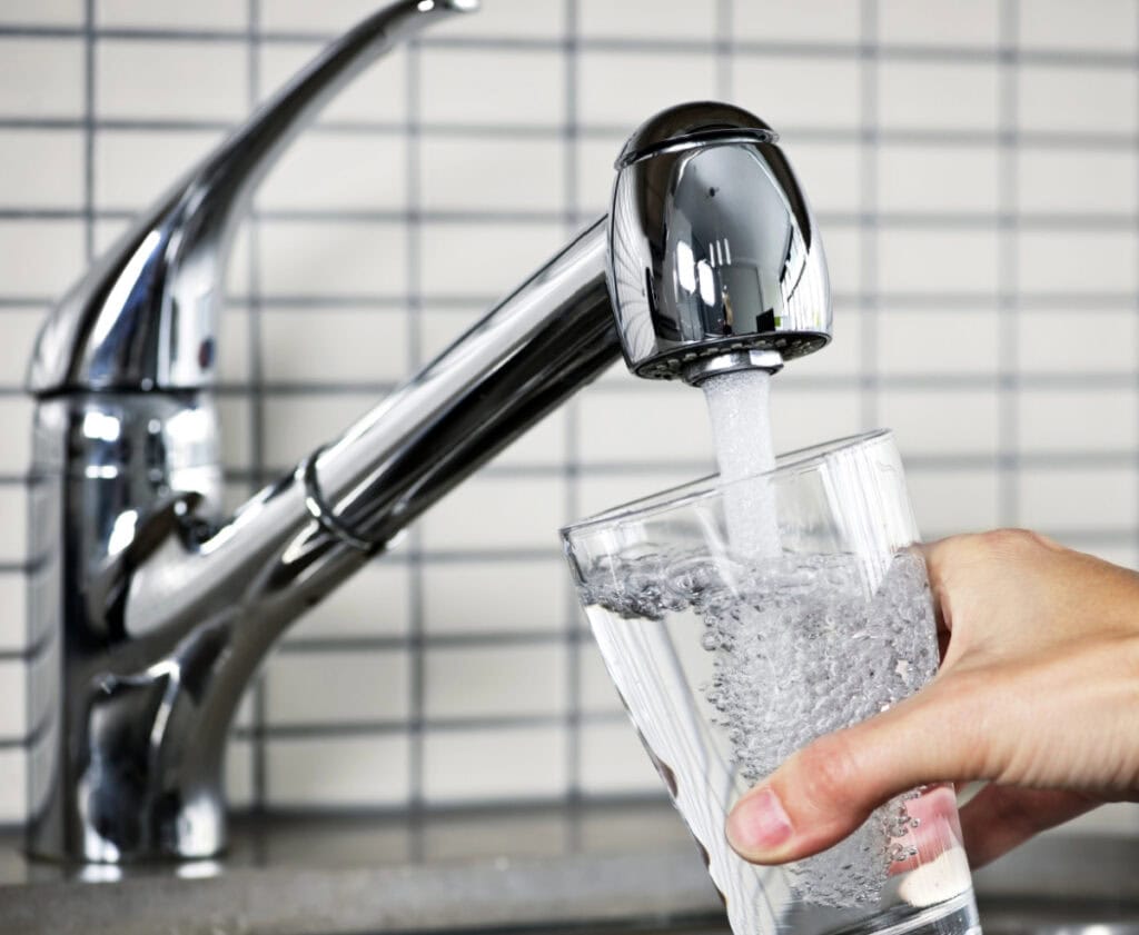 glass of water being filled at sink