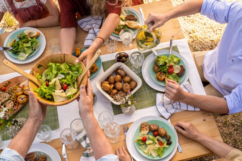 family at dinner table passing bowls of food