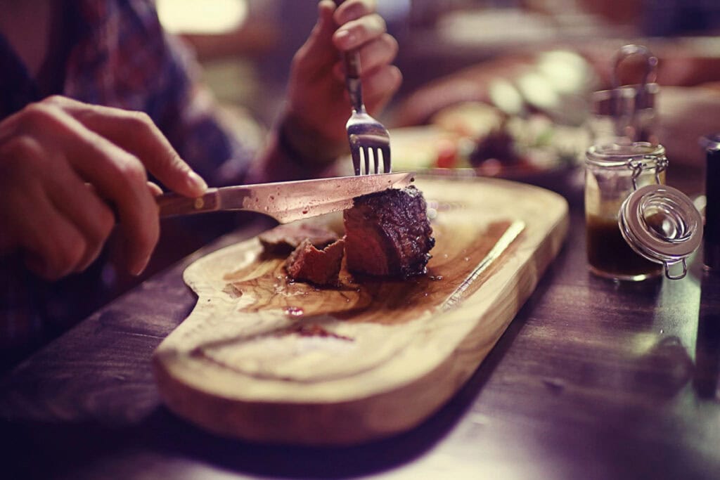 person eating steak at a restaurant