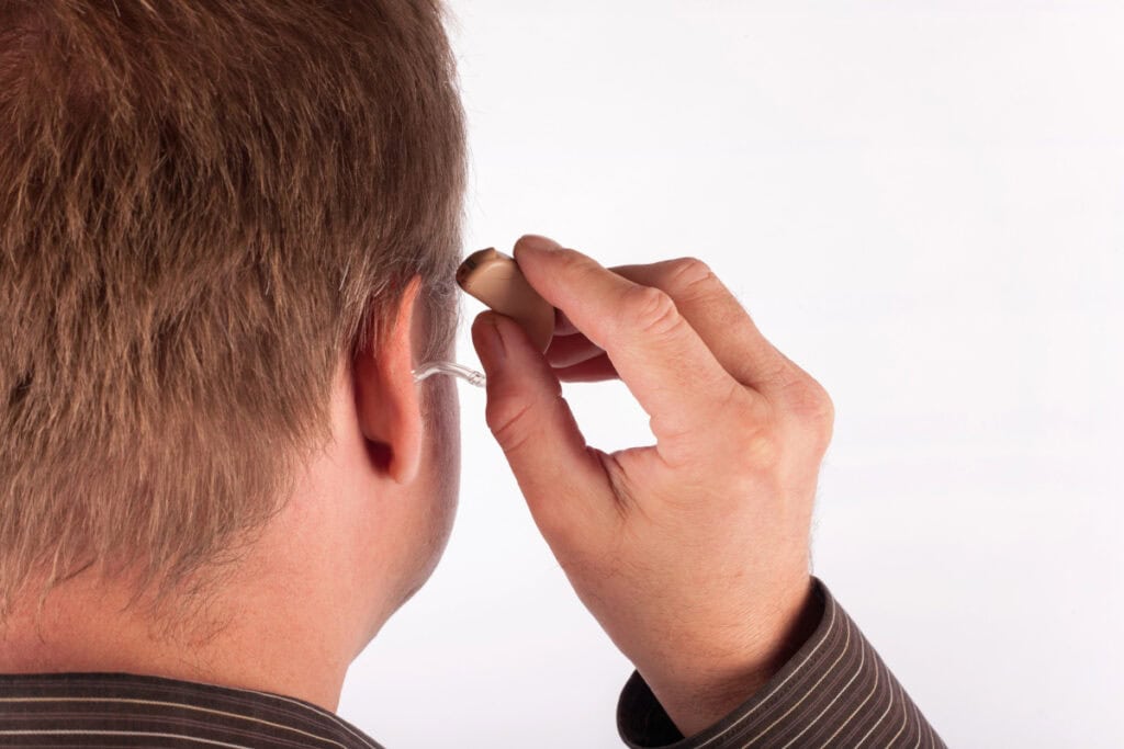 man putting in a hearing aid