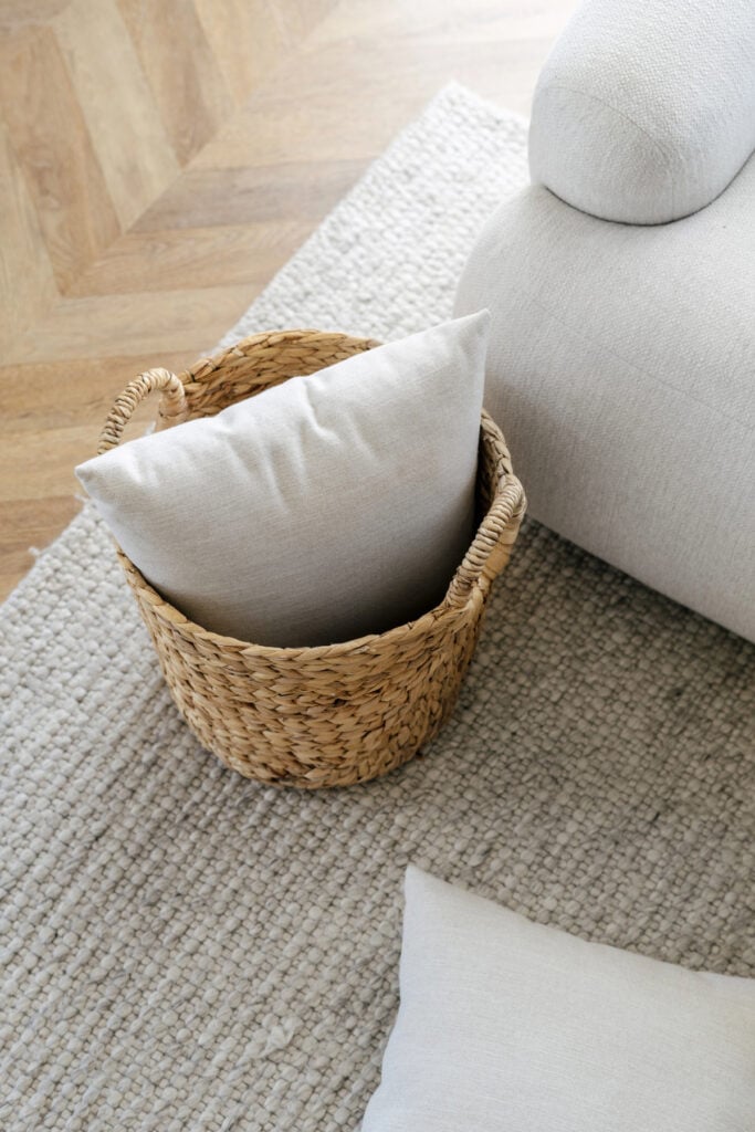 basket with pillow in it on a rug